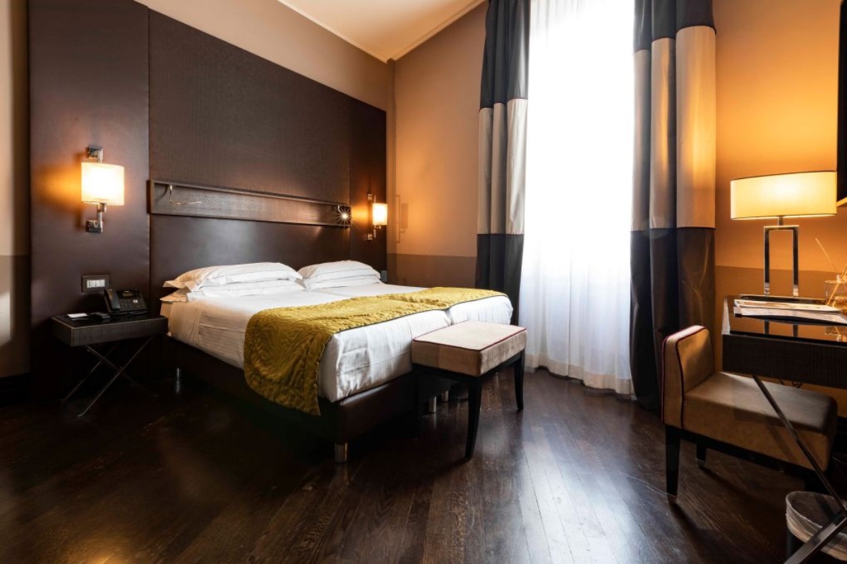 Rome Times Hotel - Large double bedroom, with dark wood floor and full-length window.