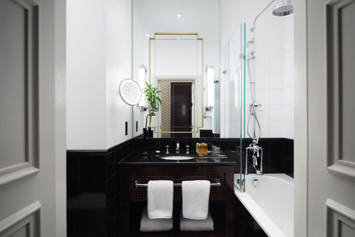 Sofitel London St James - a bathroom with a black and white sink and shower