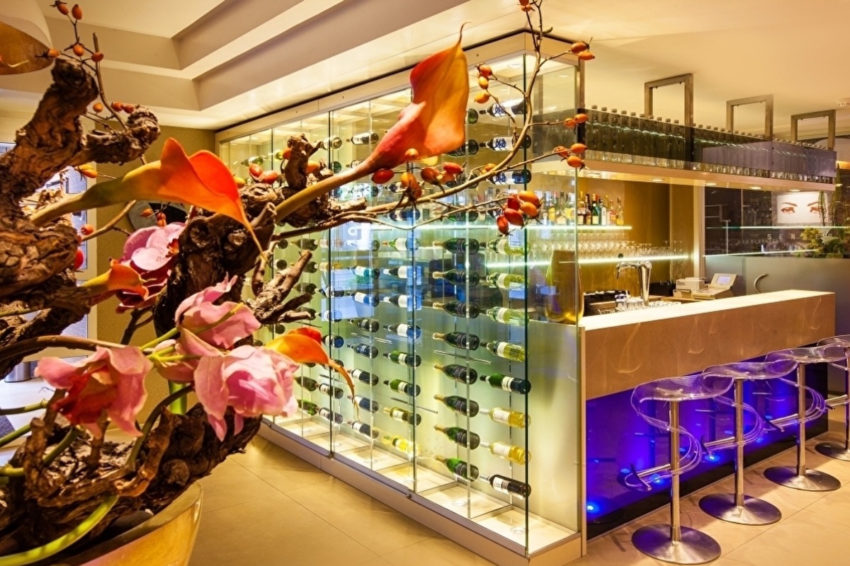 The Albus Hotel - a glass display case with wine bottles on it