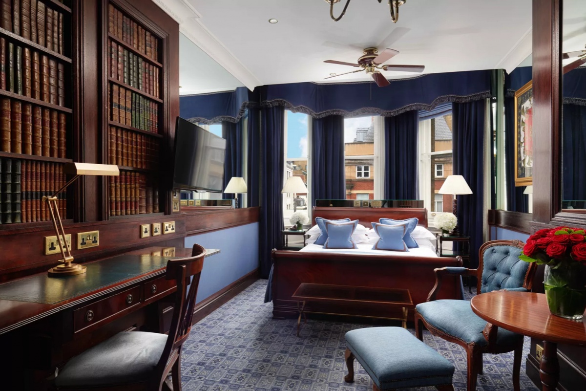 The Chesterfield Mayfair - a room with a bed and a desk and a bookcase