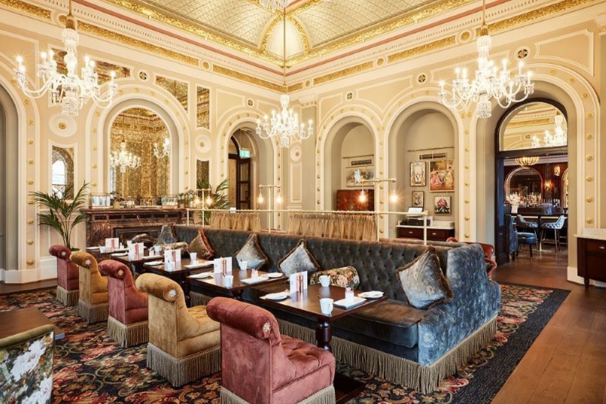 The Clermont, Charing Cross - a room with a large couch and tables