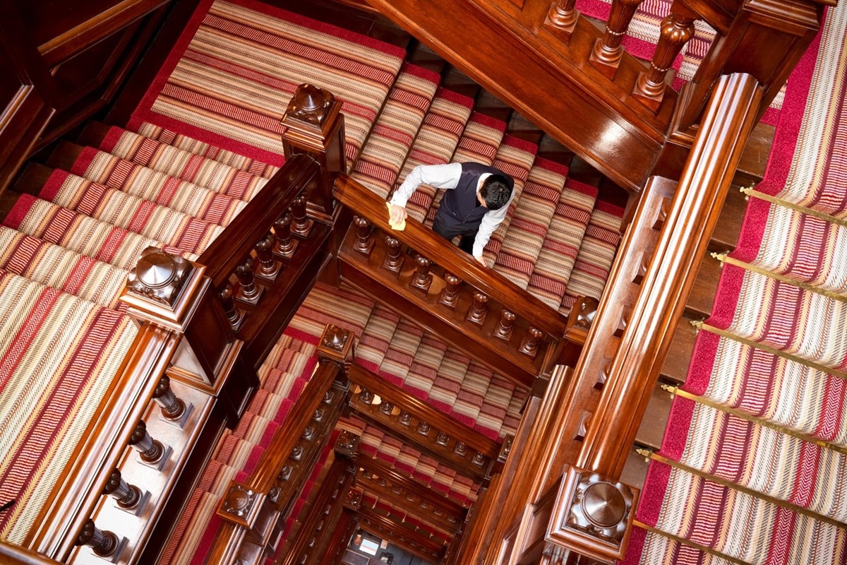 The Connaught - a man cleaning the stairs