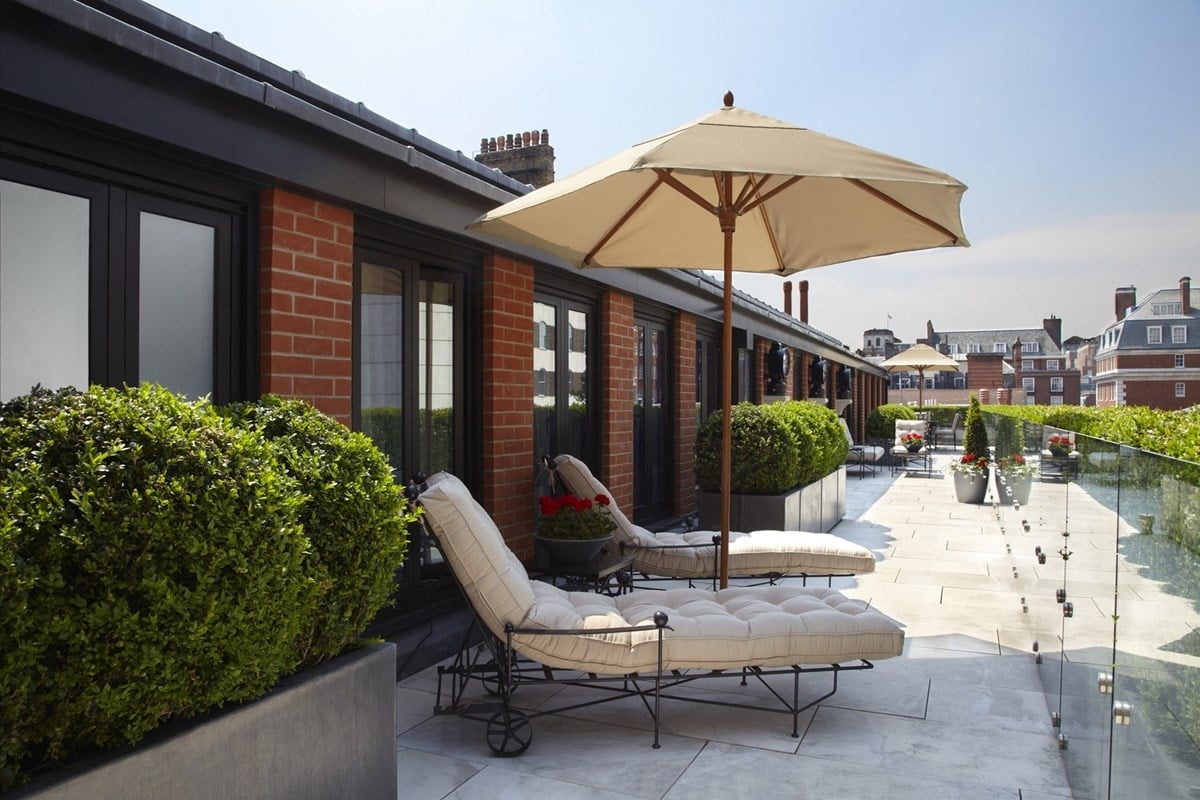 The Connaught - a patio with chairs and umbrella