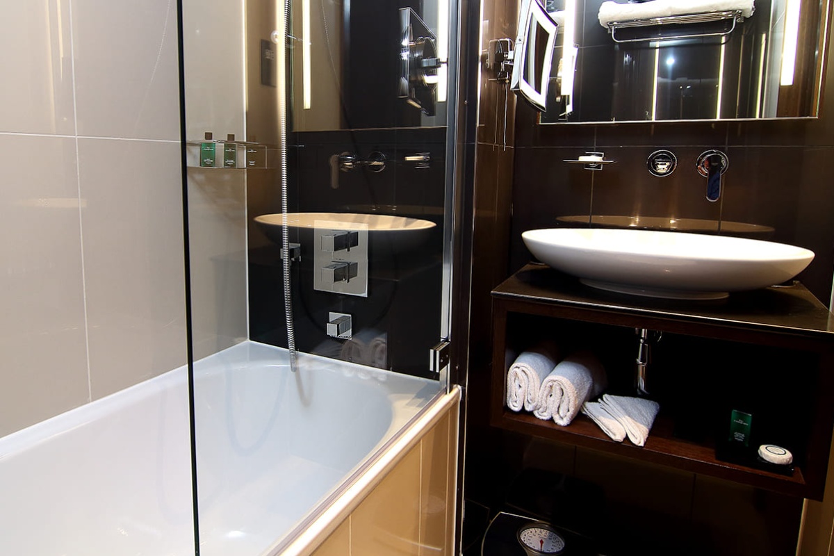 The Piccadilly London West End - a bathroom with a glass shower door