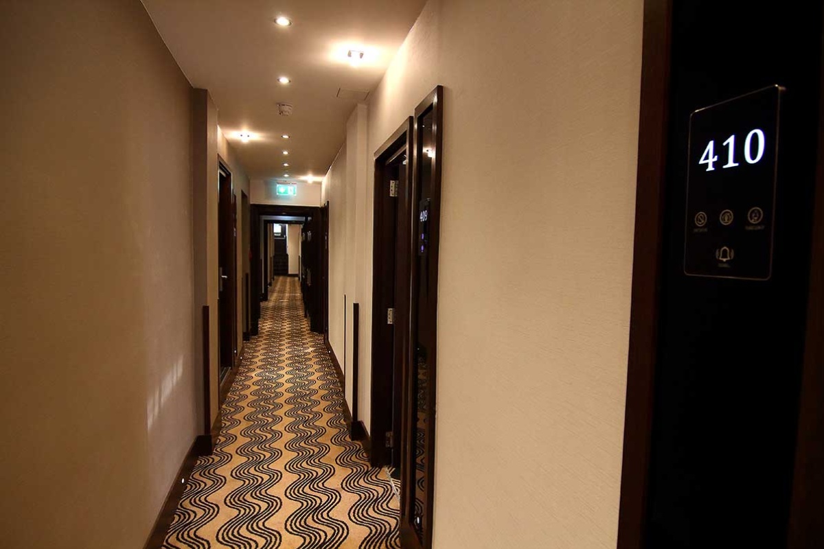 The Piccadilly London West End - a long hallway with doors and carpet