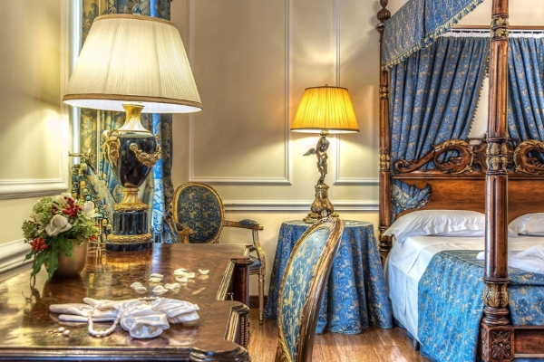 Albergo del Senato - a bedroom with blue curtains and a lamp