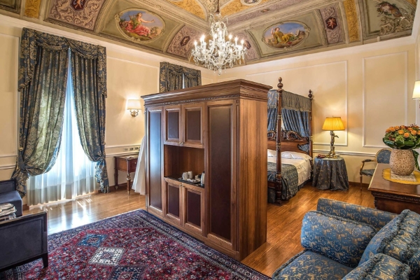 Albergo del Senato - a room with a bed and a chandelier