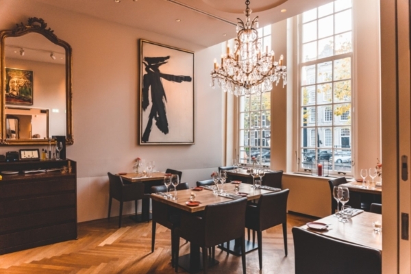 Ambassade Hotel - a room with tables and chairs and chandelier