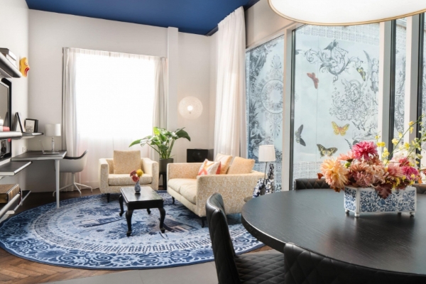 Andaz Amsterdam Prinsengracht - a living room with a blue and white rug and a couch