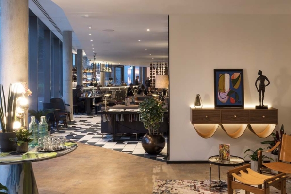 Bankside Hotel, Autograph Collection - a room with a black and white checkered floor and a table with chairs and a painting on the wall