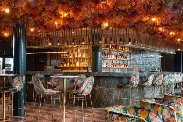 Canopy by Hilton London City - a bar with colorful chairs and a bar counter