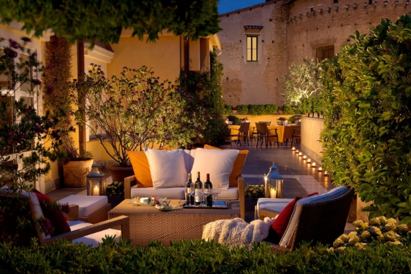 Capo D'Africa Hotel  Colosseo - The outside terrace seating area at night.