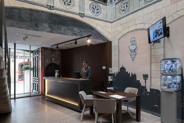 Catalonia Catedral - a man standing at a reception desk