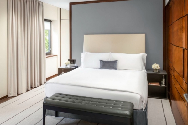 COMO The Halkin, London - a bed with a bench in a room