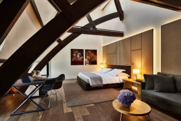 Conservatorium Hotel - a bedroom with a bed and a chair