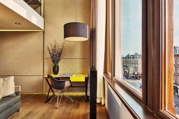 Conservatorium Hotel - a room with a yellow desk and a lamp