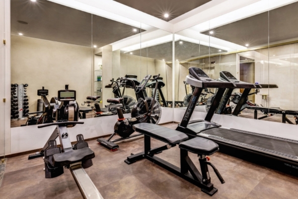 Dharma Boutique Hotel & Spa - Gym with mirrored walls and exercise machines.