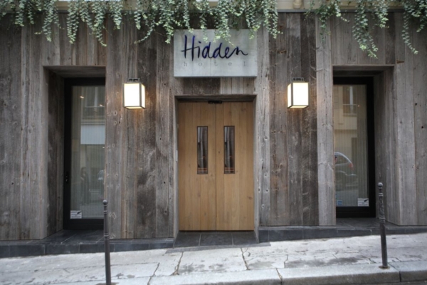 Hidden Hotel - a wooden building with two double doors