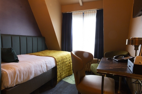 Hotel Aalders - a hotel room with a desk chair and a bed