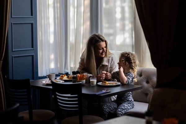 Hotel Aalders - a woman and child sitting at a table