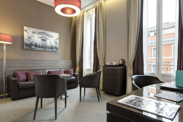 Hotel Artemide - Hotel room with a lounge area and full-height windows.