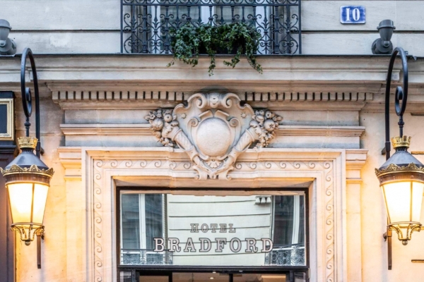 Hotel Bradford Elysees - Astotel - a building with a balcony and a sign