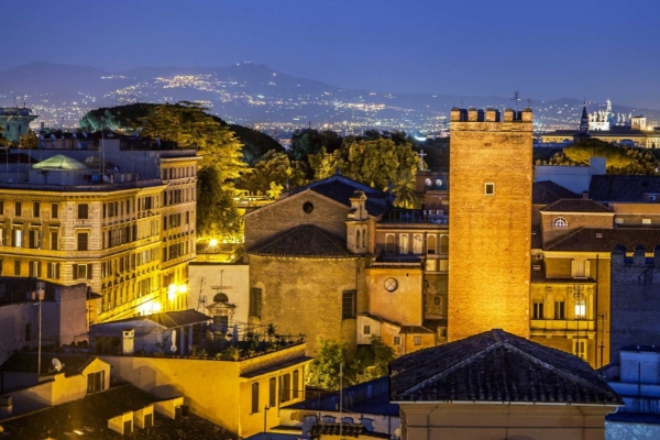 Hotel Colosseum - Rooftop terrace at night with a view of Rome.