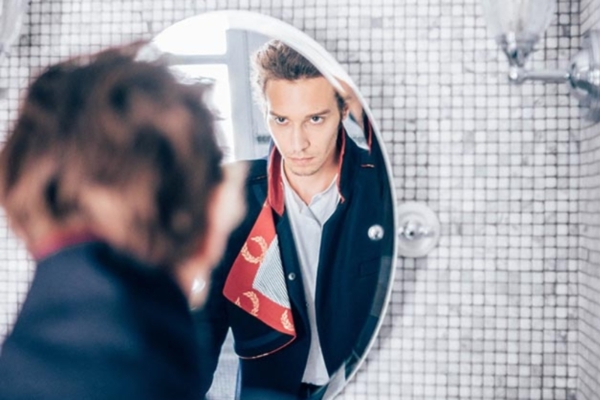 Hotel de JoBo - a man looking at himself in a mirror