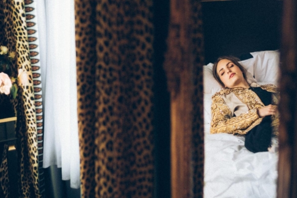 Hotel de JoBo - a woman lying in bed with eyes closed