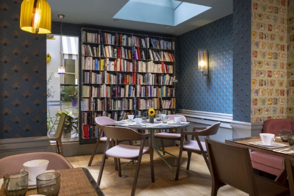 Hotel de Londres Eiffel - a room with a book shelf and table