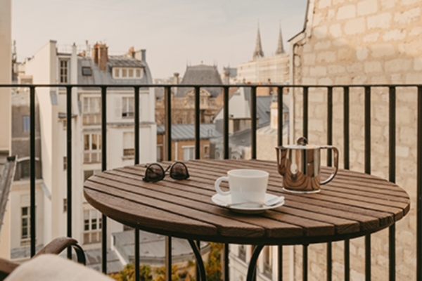 Hotel d'Orsay - Esprit de France - a table with a cup and sunglasses on it