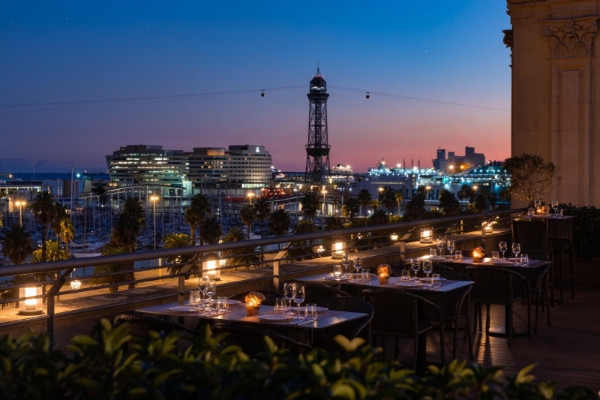 Hotel Duquesa de Cardona - a table set up on a rooftop with a city in the background