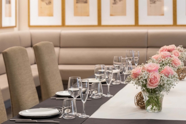 Hotel Duquesa de Cardona - a table with a vase of flowers and glasses