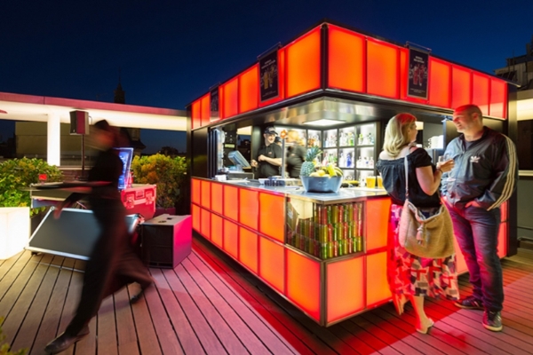 Hotel Jazz - a woman standing next to a food stand