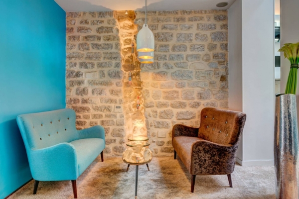 Hotel Joyce - Astotel - a room with a stone wall and two chairs