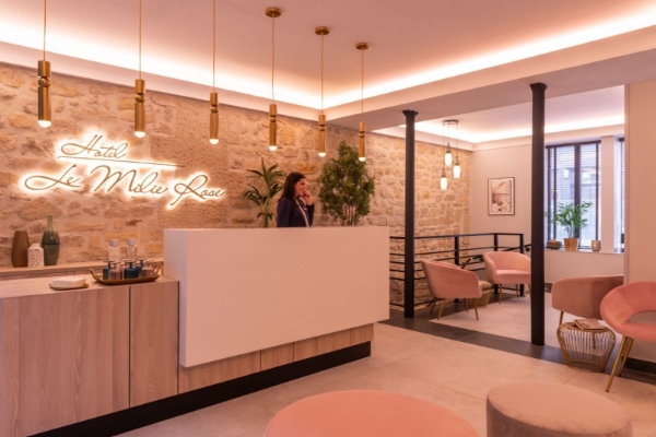 Hotel Le Milie Rose - a woman standing at a reception desk