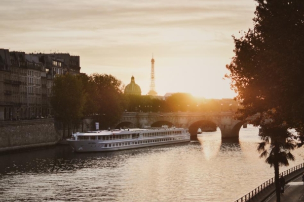 Hotel Le Walt - a boat on a river with a bridge and a tower in the background