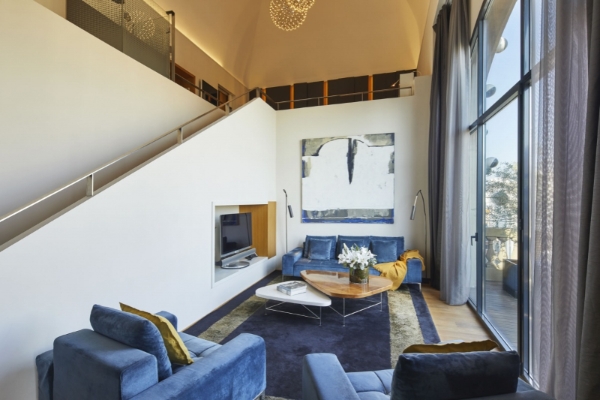 Hotel Ohla Barcelona - a living room with a blue couch and a blue rug