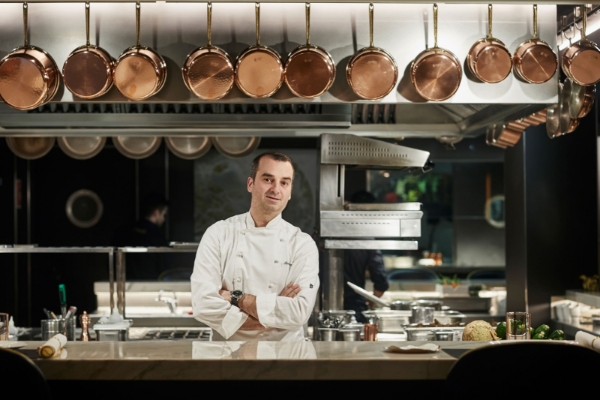 Hotel Ohla Barcelona - a man in a chef's uniform standing in a kitchen