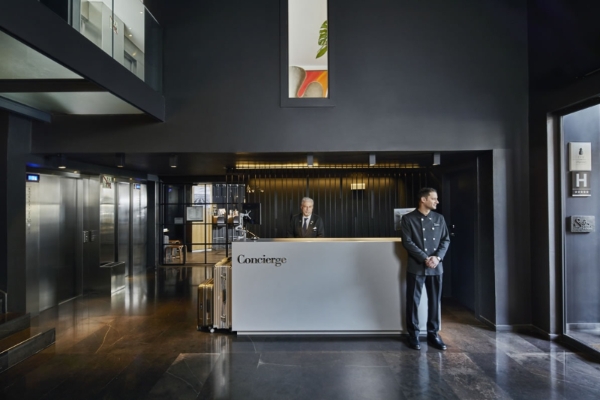 Hotel Ohla Barcelona - a man standing behind a reception desk in a hotel