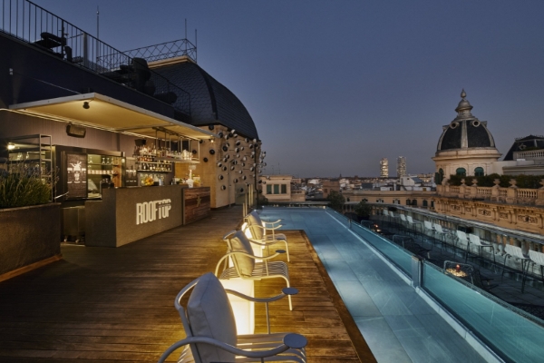 Hotel Ohla Barcelona - a rooftop bar with chairs and a pool