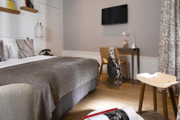 Hotel Signature St Germain des Pres - a bedroom with a bed and a tv on the wall