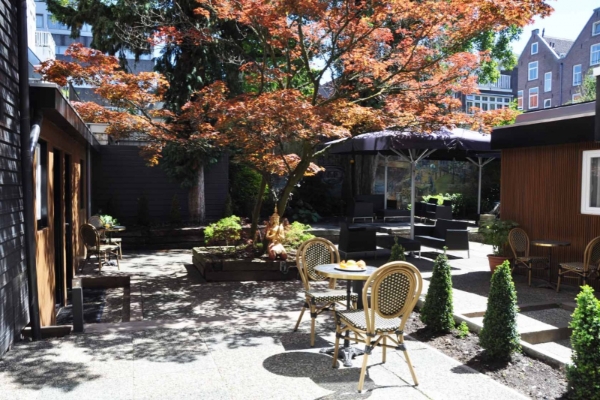 Huygens Place - a patio with tables and chairs