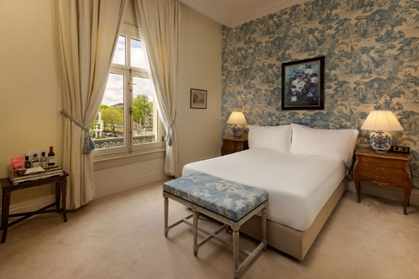 Intercontinental Amstel Amsterdam - a bedroom with a bed and a bench