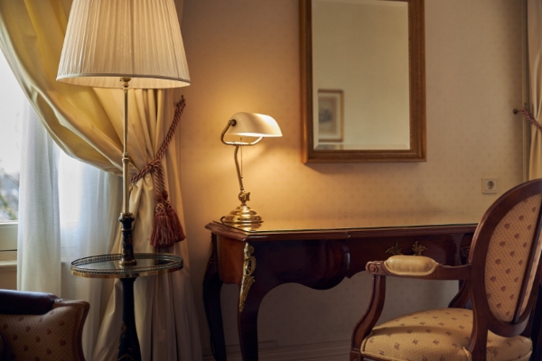 Intercontinental Amstel Amsterdam - a lamp on a table next to a mirror