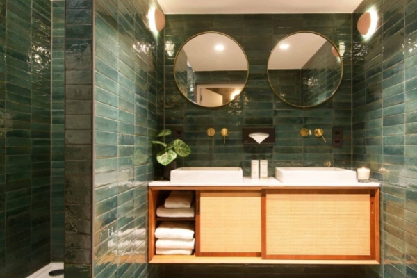 Jan Luyken Amsterdam - a bathroom with green tile walls and a double sink