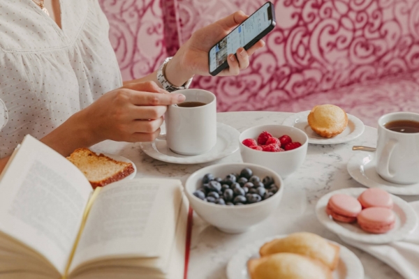 La Maison Favart - a person holding a phone and a cup of coffee