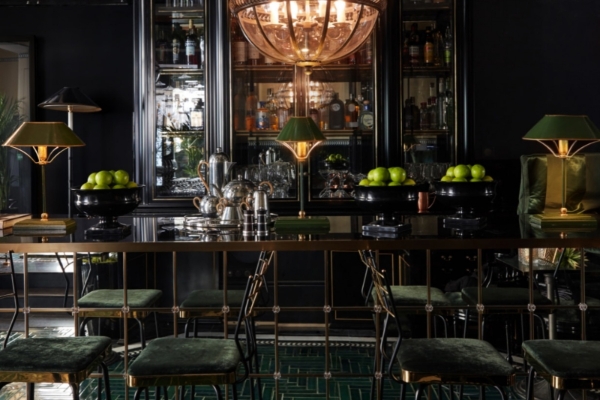 Monsieur George Hotel & Spa - a bar with a chandelier and green chairs