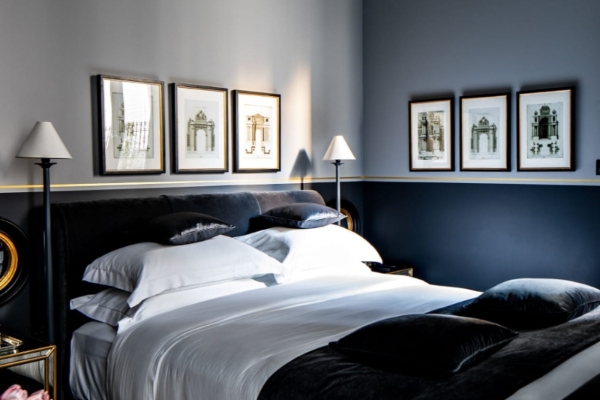 Monsieur George Hotel & Spa - a bed with white sheets and black pillows