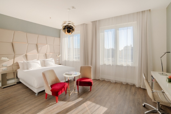 NH Collection Roma Palazzo Cinquecento - Large bright hotel room with wooden floor.